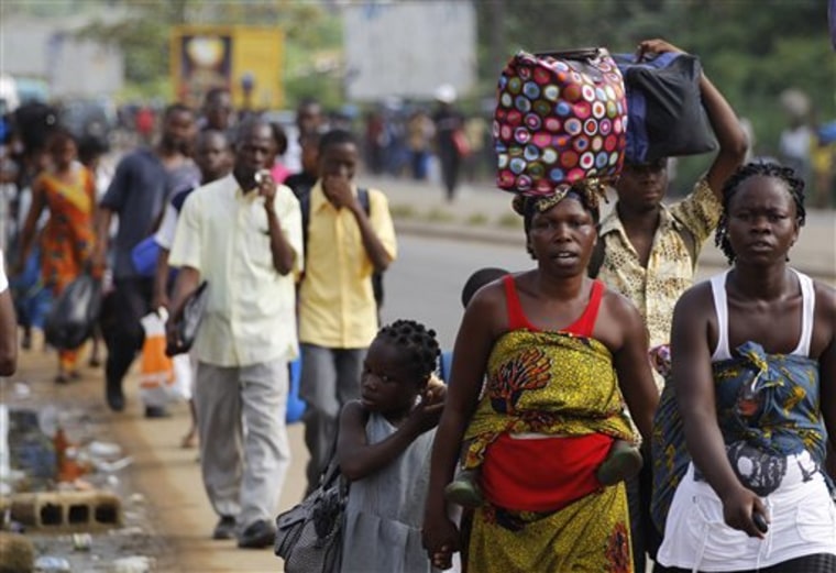 Residents of the Abobo district carry their belongings as they flee the neighborhood which has become a hub for street violence in the nation's ongoing political standoff, in Abidjan, Ivory Coast on Monday. 